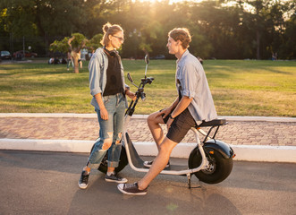 Lovely young couple with electric bike. Modern city transportation