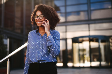 Female business professional walking outside using phone