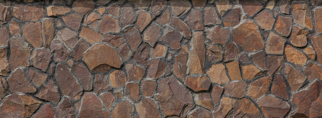 A wall of large rough stones, a stone fence. Beautiful natural stones. Building texture