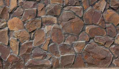 A wall of large rough stones, a stone fence. Beautiful natural stones. Building texture