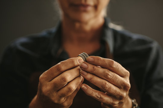 Jewelry maker hands inspecting a silver ring