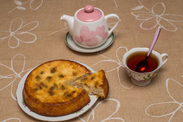 Still life with tea cup, piece of pie, plate, teapot