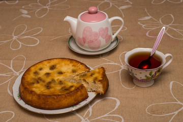 Still life with tea cup, piece of pie, plate, teapot