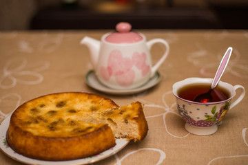 Still life with tea cup, piece of pie, plate, teapot