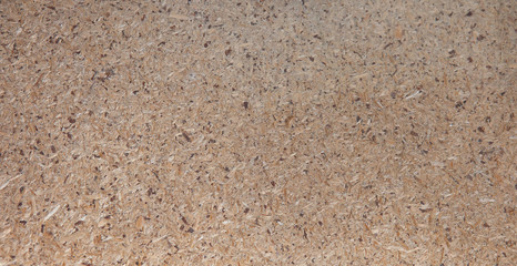 OSB boards are made of brown wood chips sanded into a wooden background. Top view of OSB wood veneer background, tight, seamless surfaces