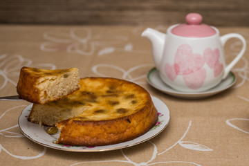 Still life with tea cup, piece of pie, plate, teapot