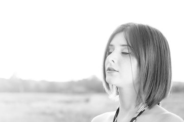Portrait of a beautiful girl with closed eyes in a field. Relax and enjoy the solitude. Close-up