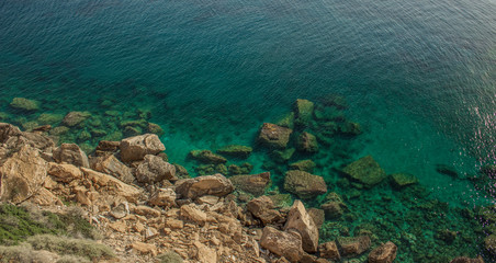 tropic vivid colorful mountain rocks and blue green water surface with waves from above in warm colorful summer day weather