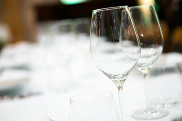 Beautifully decorated table with empty white plates, glasses and cutlery  on luxurious tablecloths