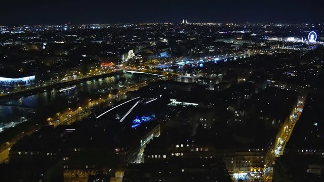 Pan over the night cityscape in Paris including the Seine River  and Rue de Paris (France)