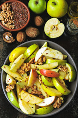 Appetizing apple salad. Vegan bowl of apple salad with walnuts. Healthy autumn salad with apples, nuts, flax seeds and spices.