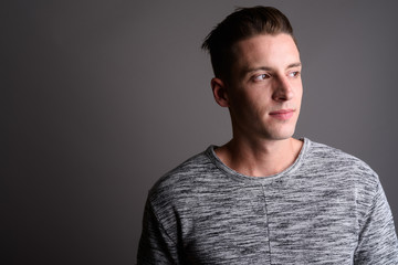 Young handsome man thinking and looking away