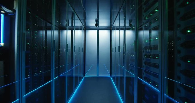 Wide movement shot of a long hallway full server racks in a modern data center