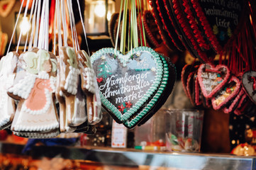 Traditional German Gingerbread heart, so called Lebkuchenkerz, a baked cookie with sugar icing, hanging at stall at Nuremberg Christmas market sold as gift for loved ones or souvenir
