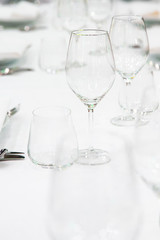 Beautifully decorated table with empty white plates, glasses and cutlery  on luxurious tablecloths