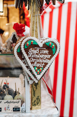 Traditional German Gingerbread heart (Lebkuchenherz) with sugar icing hanging at market stall at the Christmas market in Nuremberg saying 'Gruß vom Nürnberger Christkindlesmarkt', a gift or souvenir