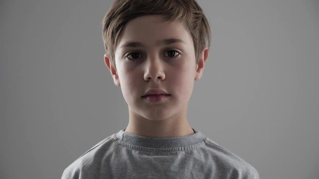 Portrait of cute young 11 - 12 year old boy looking at the camera on white background