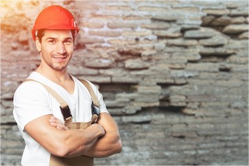 Young handsome man in work uniform with red helmet