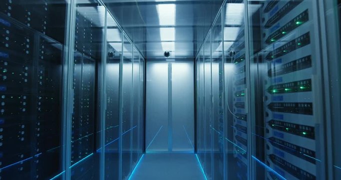 Wide movement shot of a long hallway full server racks in a modern data center