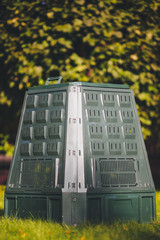 compost bin on green grass and foliage background