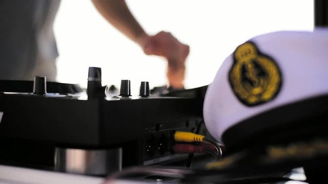 Dj Playing Music On Yacht Party With Professional Mixer And Turntable Next To A Navy Navy Sailor Captain Hat