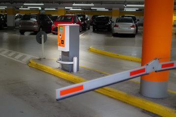 Parkscheinautomat hinter der Schranke am Ausgang einer Tiefgarage