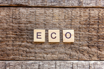 Inscription ECO letters word on old rustic wooden backdrop. Eco Village abstract environmental background. Nature protection energy saving ecology concept. Flat lay top view copy space