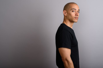 Profile view of handsome bald man looking at camera