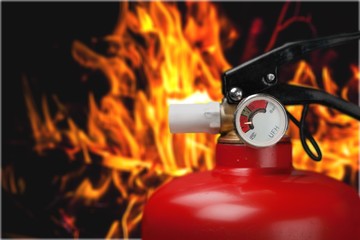 Red fire extinguisher and flames, close-up view