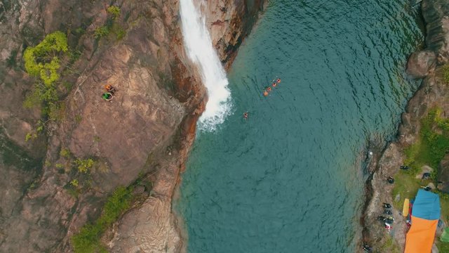 Aerial: People enjoying the beautiful nature at a waterfall in the jungle