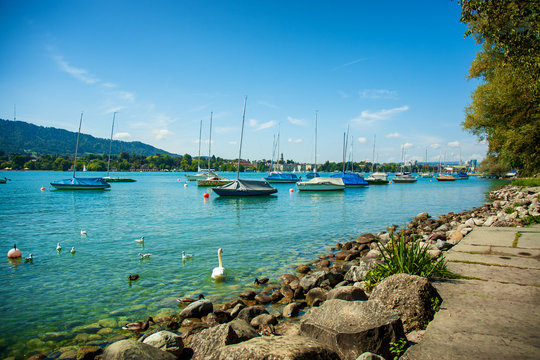 Turkusowe jezioro z jachtami na tle g&oacute;r