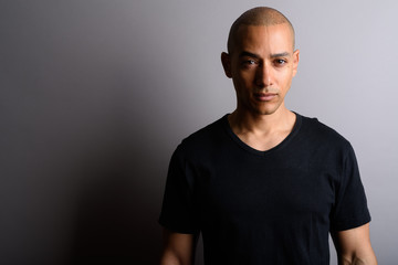 Obraz premium Handsome bald man wearing black shirt against gray background