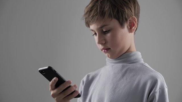 Portrait of Young Child Boy using Smartphone on white background