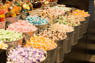 Buckets filled with taffy candy at a candy shop.