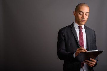 Handsome bald businessman holding clipboard and planning