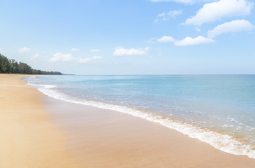 Fototapeta na wymiar Close up white soft wave rolling splash on empty tropical sandy beach in sunny day