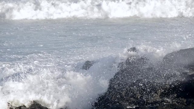 Close up of waves crashing against a rock