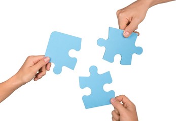 Closeup on Hands Combining Puzzle Pieces Together