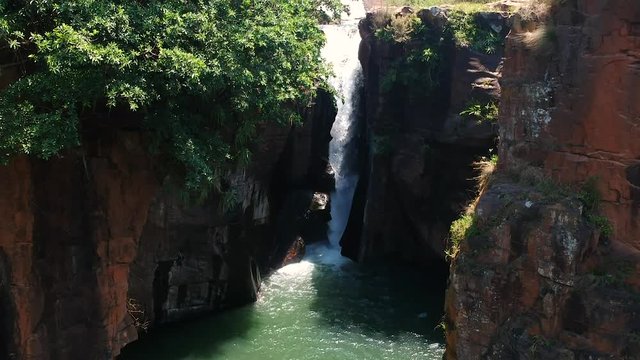 Aerial drone shot of a river with a waterfall in the jungle of South Africa.