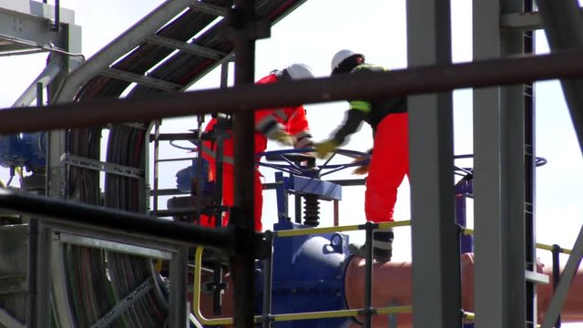 Two workers turing a wheel.
