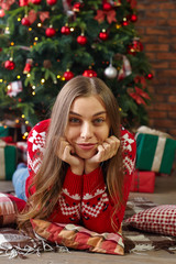 beautiful young woman lies against a Christmas tree,  New year concept.