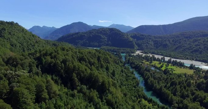 Aerial view at low altitude of the Traidor River surrounded by native and pristine forest, Chilean Patagonia