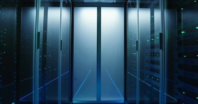 Wide movement shot of a long hallway full server racks in a modern data center
