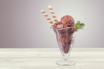 Chocolate ice cream in glass on wooden table