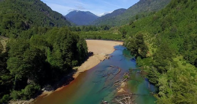 Aerial view at low altitude of the Traidor River surrounded by native and pristine forest, Chilean Patagonia