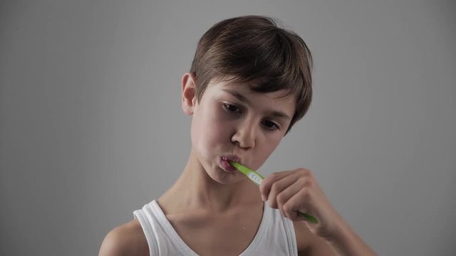 Child boy cleans his teeth and suffers from severe toothache. Dental problems
