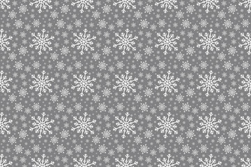 White Snowflake seamless pattern on a silver grey colored background. Various sized snowflakes are repeated through the design for a Christmas or Winter textured effect.