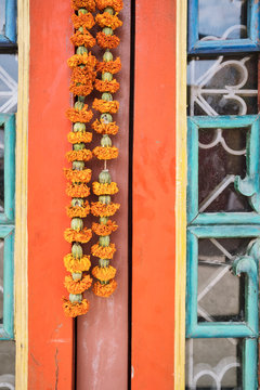 A marigold garland hangs on a colorful door in Kathmandu 