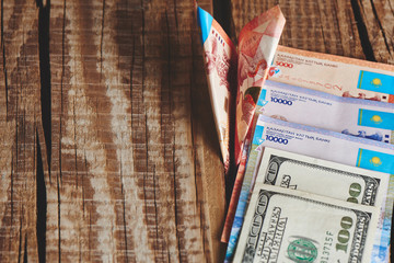 Dollars and tenge on a wooden background. Kazakhstan currency. Business and money..