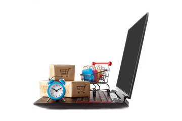 Internet store / concept of sale and delivery of e-commerce: a basket with multi-colored packages and boxes with the logo of a trolleybus on a laptop keyboard and a watch, on a white background